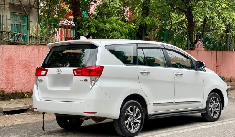 Rear view of a white Innova Crysta showing the tailgate and boot for luggage