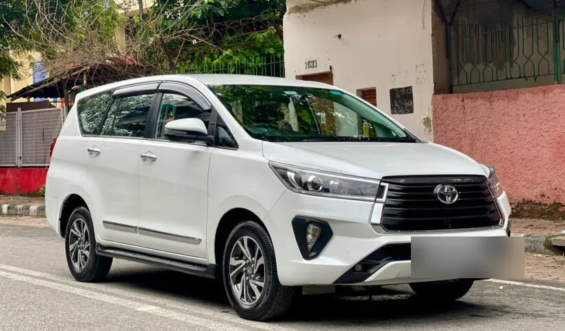White Innova Crysta three-quarter side view parked on a Chennai street