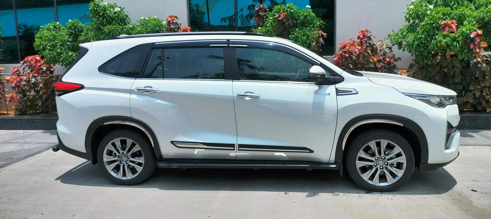 Side profile of a white Toyota Innova Hycross with alloy wheels