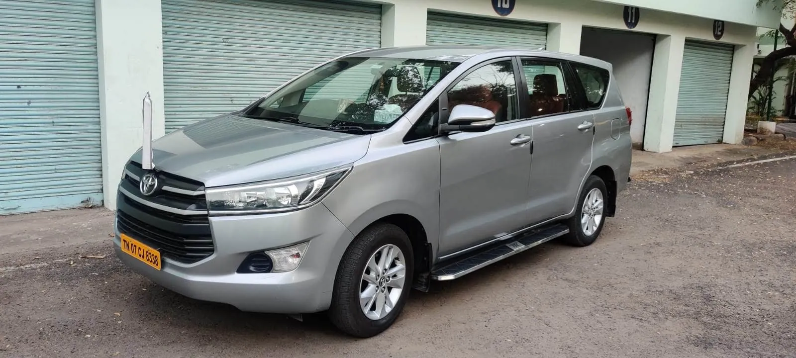 Silver Innova Crysta from the Sri Meenakshi Travels fleet parked at the Chennai garage