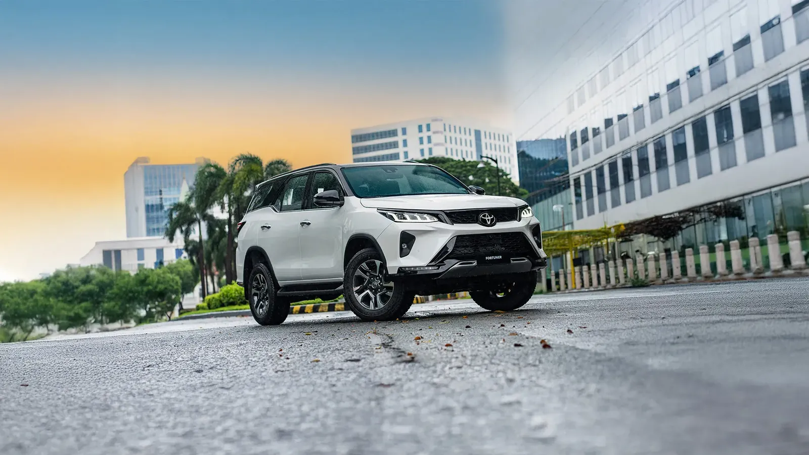 White Toyota Fortuner on a city road at sunset