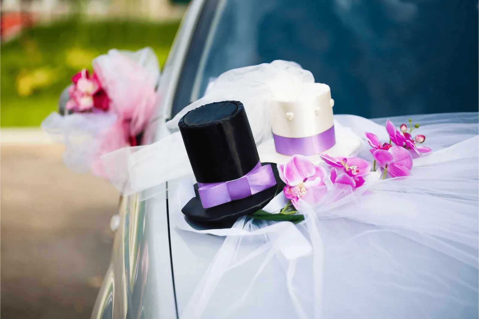 Bride and groom top-hat decoration with ribbons on a wedding car